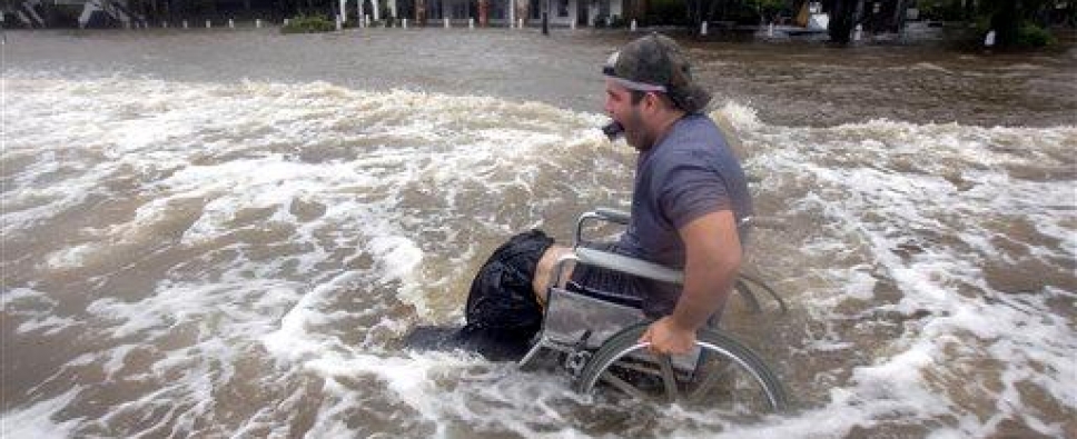 Man in a wheelchair going though flood waters