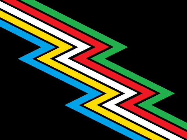 Old disability pride flag. A black background with fived colored zig-zap stripes cutting across diagonally. The colors from left to right are blue, yellow, white, red, and green.